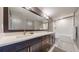 Modern bathroom featuring a double vanity with quartz countertop and a shower-over-tub with glass door at 11194 W Yucca, Littleton, CO 80125
