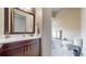 Well-lit bathroom featuring a cherry vanity, modern fixtures, and neutral-toned tiles at 11194 W Yucca, Littleton, CO 80125