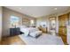 Bright bedroom with neutral tones, plush rug, bench, and hardwood flooring throughout at 11194 W Yucca, Littleton, CO 80125