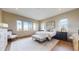 Bright bedroom with neutral tones, plush rug, bench, and multiple windows offering stunning views at 11194 W Yucca, Littleton, CO 80125