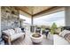 Inviting covered deck with stone accents, a fire pit, comfortable seating, and scenic views at 11194 W Yucca, Littleton, CO 80125