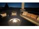 Cozy covered deck at night with a fire pit, comfortable seating, and scenic city lights view at 11194 W Yucca, Littleton, CO 80125