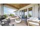 Relaxing covered deck with a fire pit, comfortable seating, stone accents, and scenic views at 11194 W Yucca, Littleton, CO 80125