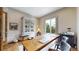 Bright home office with a large wooden desk, decorative cabinet, and sliding glass door to the outdoors at 11194 W Yucca, Littleton, CO 80125