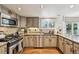 Spacious kitchen featuring stainless steel appliances, tile backsplash, granite countertops, and hardwood floors at 10068 Granite Hill Dr, Parker, CO 80134