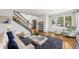 Bright living room with hardwood floors, neutral decor, staircase, and large window with neighborhood views at 10068 Granite Hill Dr, Parker, CO 80134