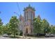 Beautiful vintage brick building with large windows, manicured landscaping and mature trees at 1021 E 23Rd Ave, Denver, CO 80205