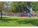 Colorful playground equipment in a park setting surrounded by green grass and mature trees at 1021 E 23Rd Ave, Denver, CO 80205