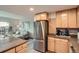Open kitchen with stainless steel refrigerator and wood cabinets adjacent to the living room at 1150 Vine St # 1006, Denver, CO 80206