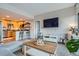 Open concept living room and kitchen with a breakfast bar, modern furniture, and a large TV at 1150 Vine St # 1006, Denver, CO 80206