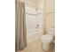 Full bath with a tiled shower and tub, featuring a shower curtain, plus a standard toilet at 7895 Julsburg Cir, Littleton, CO 80125