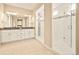 Bright bathroom featuring dual sinks, granite counters, and a sleek glass-enclosed shower with mosaic accents at 7895 Julsburg Cir, Littleton, CO 80125