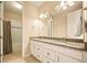Bathroom vanity with double sinks, granite counters, and updated lighting fixtures at 7895 Julsburg Cir, Littleton, CO 80125