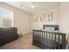 Bedroom featuring a crib, ceiling fan, and light-filled windows with decor at 7895 Julsburg Cir, Littleton, CO 80125