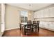 A dining room features a wooden table with seating for six, a modern light fixture, and a window for natural light at 7895 Julsburg Cir, Littleton, CO 80125