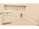 Functional laundry room features tile flooring, white cabinets, countertop, and washer/dryer hookups at 7895 Julsburg Cir, Littleton, CO 80125