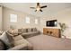 Spacious living room with large windows, plush sofas, carpeted floor, and a modern television at 7895 Julsburg Cir, Littleton, CO 80125