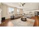 Bright living room boasts an open floor plan, hardwood floors, ceiling fan, and a large comfortable sectional sofa at 7895 Julsburg Cir, Littleton, CO 80125