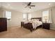 Spacious bedroom with plush carpet, a ceiling fan, and large windows allowing natural light at 7895 Julsburg Cir, Littleton, CO 80125