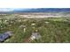 Aerial view of a secluded home nestled among mature trees and distant mountain views at 17420 Caribou Dr, Monument, CO 80132