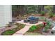 Landscaped backyard featuring a charming patio, garden beds, and mature trees at 17420 Caribou Dr, Monument, CO 80132
