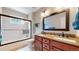 Bathroom featuring a shower-over-tub with glass enclosure and double vanity with granite counters at 17420 Caribou Dr, Monument, CO 80132
