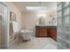 Bathroom featuring a soaking tub, skylight, tiled floors, and glass block window at 17420 Caribou Dr, Monument, CO 80132