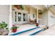 Inviting front porch with seating and decorative plants, leading to a front door with glass details at 17420 Caribou Dr, Monument, CO 80132