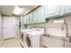 Functional laundry room features cabinets, sink, washer, and dryer for added convenience at 17420 Caribou Dr, Monument, CO 80132