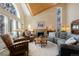 Cozy living room with a fireplace, large windows, a wooden ceiling, and comfortable seating at 17420 Caribou Dr, Monument, CO 80132