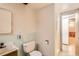 Bathroom with a vanity, toilet, shower, and neutral patterned wallpaper with a bright tile accent at 502 Nile St, Aurora, CO 80010