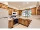 Functional kitchen with white appliances, wooden cabinets, and a white countertop at 502 Nile St, Aurora, CO 80010