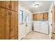 Bright laundry room with washer, dryer, cabinets, and window provides function and charm at 502 Nile St, Aurora, CO 80010