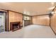 Cozy living room featuring a classic brick fireplace, wood paneling, and built-in bar area for entertaining at 502 Nile St, Aurora, CO 80010