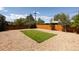 Wide angle image of a backyard with green rectangle of grass, rock ground cover, and wood fence at 5915 W 5Th Ave, Lakewood, CO 80226