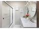 Bathroom featuring double sinks, modern fixtures, decorative signs, and a shower with glass doors at 5915 W 5Th Ave, Lakewood, CO 80226