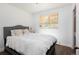 A naturally lit bedroom with a comfortable bed, neutral colors, and a large window with blinds at 5915 W 5Th Ave, Lakewood, CO 80226