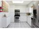 Bright kitchen with white cabinets, stainless steel appliances, and tiled floor at 5915 W 5Th Ave, Lakewood, CO 80226
