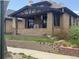Charming brick home featuring a covered porch and manicured lawn, offering classic curb appeal at 4109 Shoshone St, Denver, CO 80211