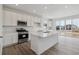 Modern kitchen with stainless steel appliances, white cabinetry, island, and ample counter space at 6646 N Nepal St, Aurora, CO 80019