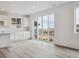 Contemporary kitchen with white cabinets, a sliding glass door, and light wood flooring at 6646 N Nepal St, Aurora, CO 80019