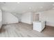 Open-concept living room with light wood floors, modern lighting, and a kitchen island at 6646 N Nepal St, Aurora, CO 80019