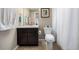 Bathroom features a dark wood vanity with white sink and toilet, along with a framed print at 9258 Rockhurst St # 303, Highlands Ranch, CO 80129