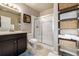 Bathroom includes a dark wood vanity, white toilet and shower behind sliding glass doors at 9258 Rockhurst St # 303, Highlands Ranch, CO 80129