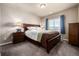 Comfortable bedroom with wood furnishings, gray carpet and abundant light from the window at 9258 Rockhurst St # 303, Highlands Ranch, CO 80129
