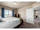 Neutral bedroom features an open doorway, closet and a window view with blue curtains at 9258 Rockhurst St # 303, Highlands Ranch, CO 80129