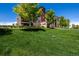 Well-maintained condominium building with lush green lawn and mature trees at 9258 Rockhurst St # 303, Highlands Ranch, CO 80129