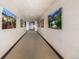Well-lit hallway with decorative landscape paintings leads to the unit's entrance at 9258 Rockhurst St # 303, Highlands Ranch, CO 80129