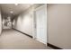 Hallway with neutral walls and carpet leads to unit entrance 303 at 9258 Rockhurst St # 303, Highlands Ranch, CO 80129