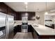 Modern kitchen featuring stainless steel appliances, dark wood cabinetry, and light countertops at 9258 Rockhurst St # 303, Highlands Ranch, CO 80129